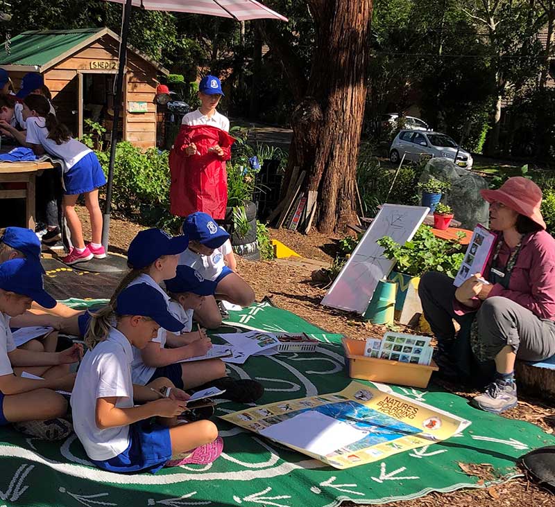 A teacher and students in an outdoor classroom setting